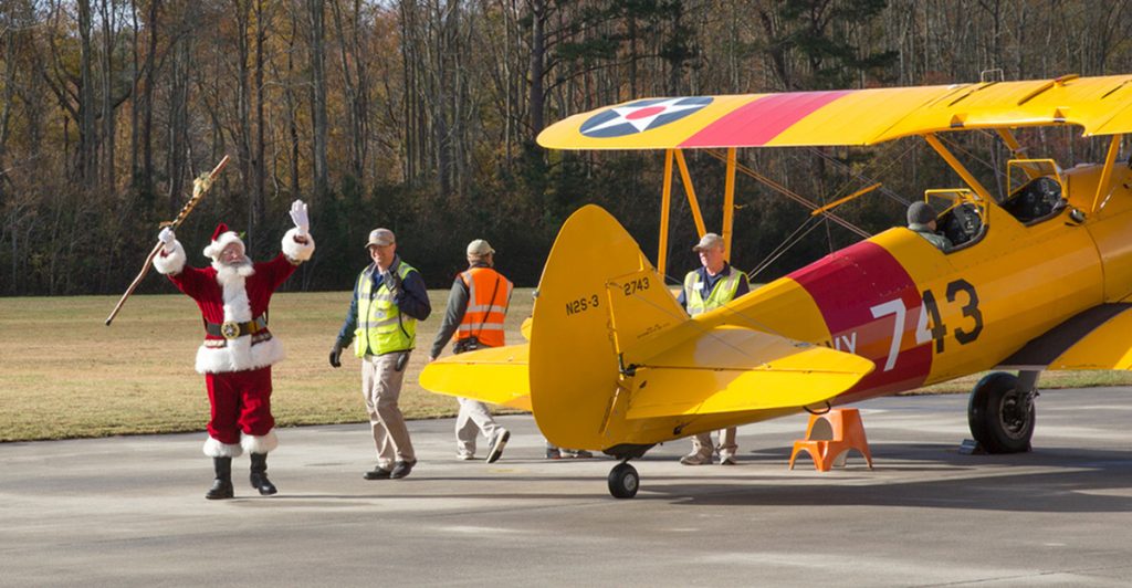 Santa arrives to Toys for Tots via vintage plane